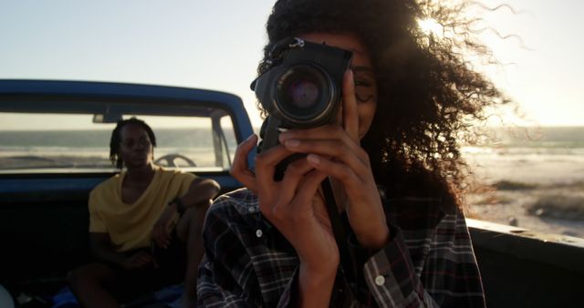 Woman Taking Photo on Beach at Sunset with Friend in Background - Download Free Stock Images Pikwizard.com