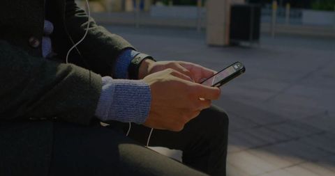 Modern Lifestyle: Man Engaged with Smartphone in Urban Setting