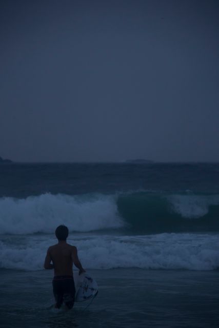 Surfer Heading into Ocean at Dusk - Download Free Stock Images Pikwizard.com
