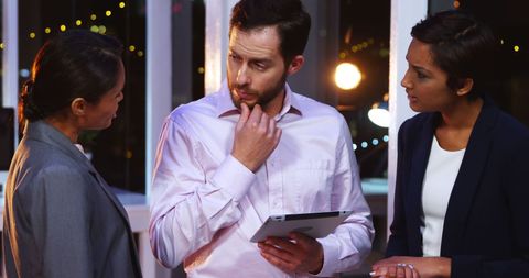 Diverse professionals collaborating in night office meeting