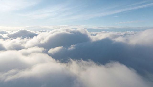 Sunlit Cumulus Cloudscape from High Altitude with Soft Blue Sky and Horizon