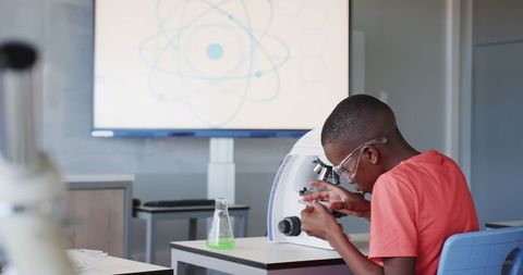 Young boy engaging in microscope science experiment