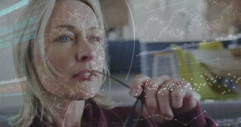 Mature woman analyzing digital data projection at home