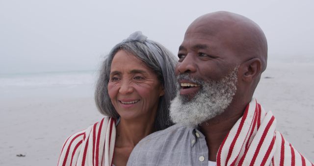 Smiling Senior Couple Wrapped in Blanket Enjoying Beach Serenity - Download Free Stock Images Pikwizard.com