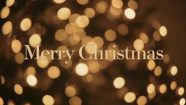 Merry christmas gold serif typography with warm bokeh lights and festive metallic glow
