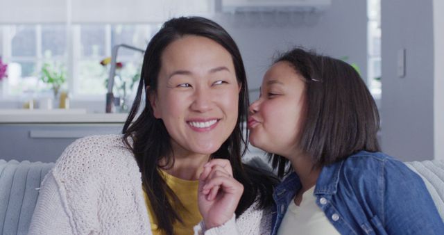 Image of happy asian daughter kissing mother in chick. Family, motherhood, relations and spending quality time together concept digitally generated image.