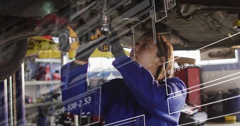Woman mechanic repairing undercarriage on lift using augmented reality diagnostics