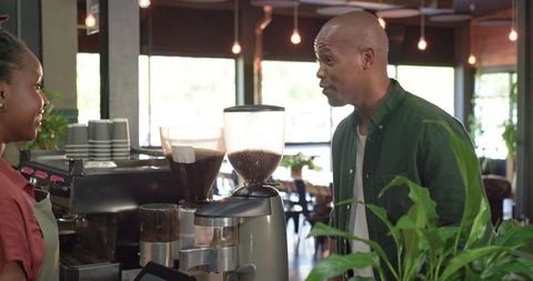 Barista and Customer Chatting at Espresso Bar in Modern Coffeehouse