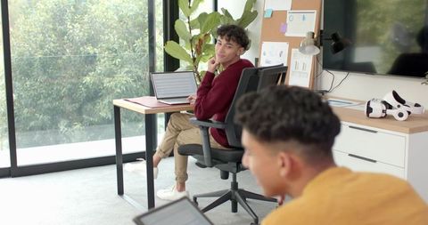 Male Coworkers Collaborating in Modern Office with VR Headset