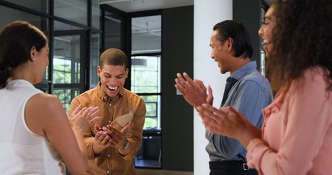 Diverse Team Celebrating and Applauding Employee Achievement in Office