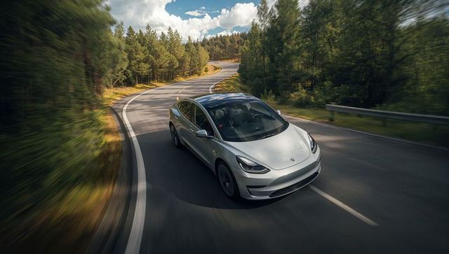 Silver Electric Sedan Navigating Scenic Mountain Road