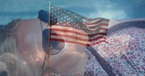Sunbathing woman with sunglasses overlaid by american flag double exposure patriotic vision