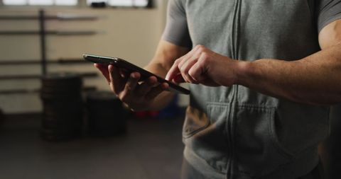 Athletic Man Using Tablet in Gym Environment