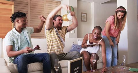 Joyful Friends Celebrating with Confetti and Cake at Home Gathering