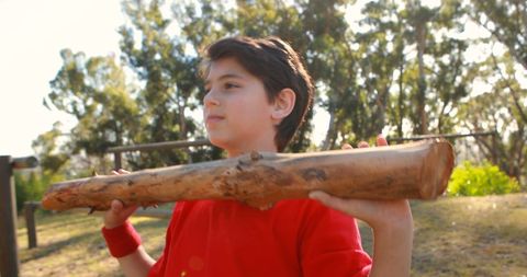 Young Boy Holding Large Piece of Wood Outdoors in Sunny Park - Download Free Stock Images Pikwizard.com