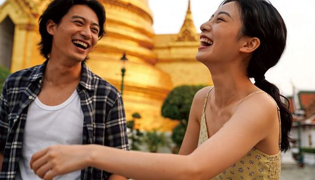 Laughing asian couple at golden pagoda courtyard, travel romance and joyful sightseeing