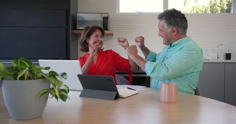 Joyful senior couple embracing technology for retirement plans