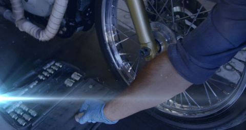 Mechanic Repairing Motorcycle Wheel in Garage with Motion Effect