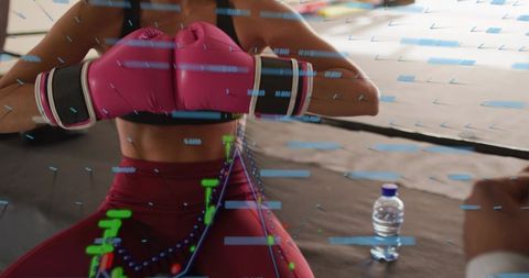 Woman boxer guarding with pink gloves in ring showing performance analytics overlay