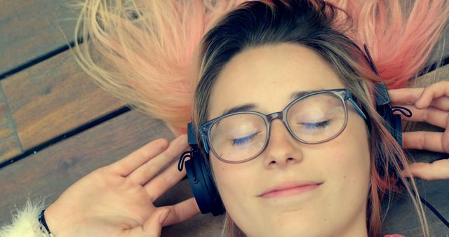 Young Woman Relaxing with Headphones and Glasses on Wooden Floor - Download Free Stock Images Pikwizard.com