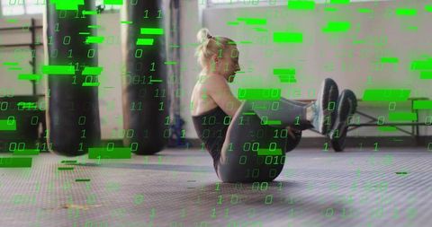Female athlete performing v-sit core hold in gym with green binary overlay