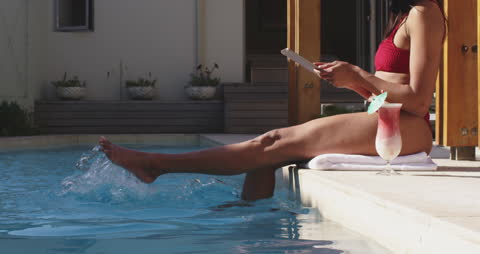 Woman Enjoying Relaxation by Poolside with Tablet