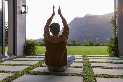 Sunset meditation on modern patio with grass-strip pavers facing sunlit mountain view