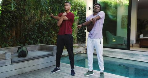 Diverse Friends Stretching Outdoors Next to Pool