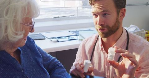 Doctor Explaining Medication to Senior Woman in Medical Office