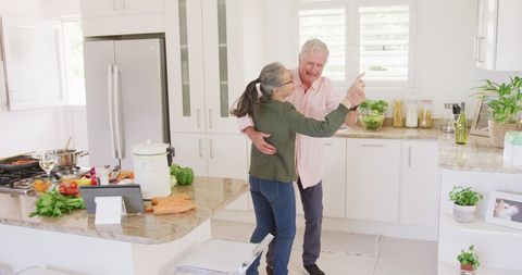 Senior Couple Dancing Blissfully in Modern Kitchen