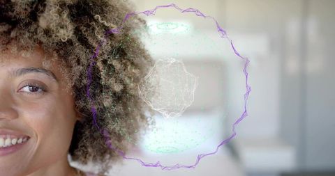 Curly-haired woman smiling, turning toward camera with holographic interface in modern living room