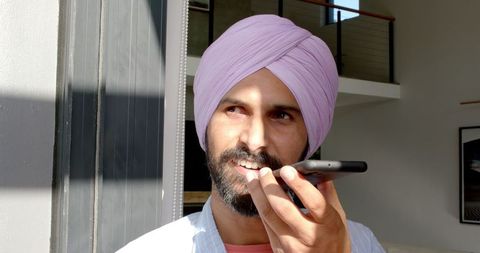 Indian Man in Pink Turban Smiling While Speaking on Smartphone