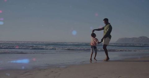 Playful Father and Son Spinning on Scenic Beach