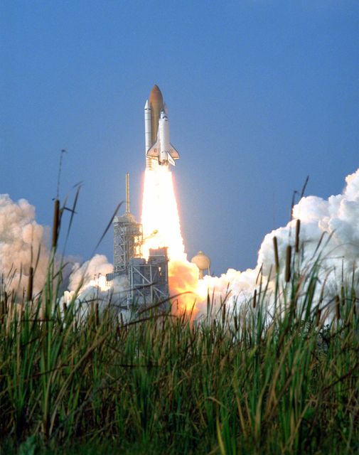This powerful and iconic image captures the thrilling moment of Space Shuttle Discovery's lift-off from Kennedy Space Center on June 2, 1998. Surrounded by Florida's naturally silent foliage, the scene accentuates the harmonious blend of technology and nature. Ideal for use in educational articles, space exploration documentaries, and science exhibitions.