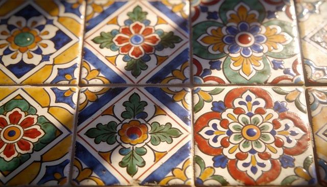 Catching diagonal sunlight on colorful hand-painted ceramic tiles with grout lines