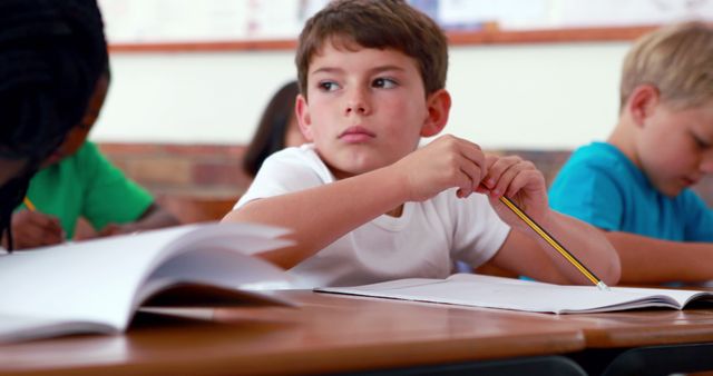 Little boy writing during class in elementary school - Download Free Stock Photos Pikwizard.com