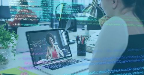Woman conducting remote video meeting on laptop at modern desk with code overlay