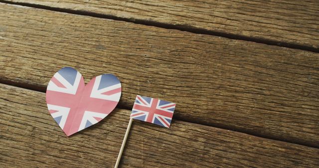 Image of flags of great britain in shape of heart and rectangle on wooden background. nationality, state symbols, patriotism and independence concept.