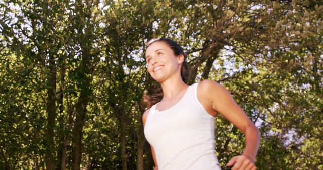 Young Woman Jogging Outdoors in Green Forest on Sunny Day - Download Free Stock Images Pikwizard.com