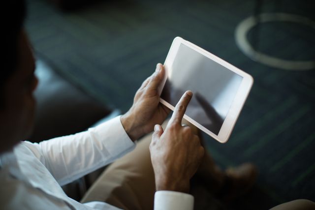 Businessman using digital tablet in office. Ideal for illustrating modern business practices, technology in the workplace, and professional settings. Useful for corporate presentations, business websites, and technology-related content.
