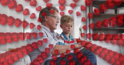 Grandfather and Grandson Sharing Tablet Time with Heart Overlay