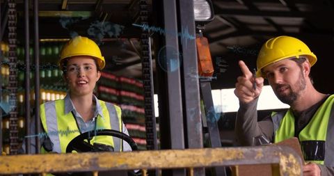 Female forklift operator receiving supervisor guidance while operating forklift in warehouse
