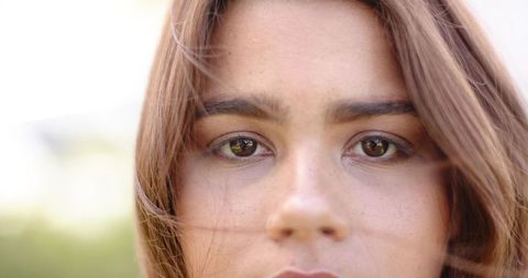 African woman looking directly at camera with calm expression and freckled skin closeup