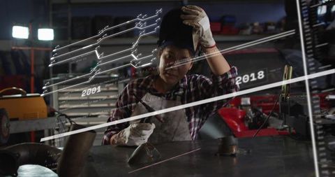 Female Welder Using AR HUD While Aligning Torch at Metal Fabrication Bench