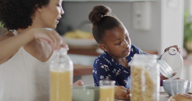 Mother and daughter having breakfast with cereal and juice - Download Free Stock Images Pikwizard.com