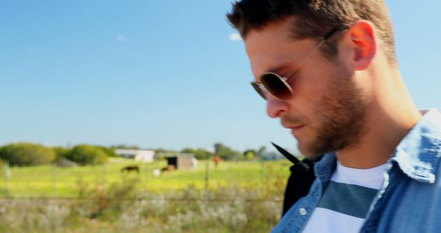 Pensive Young Man with Sunglasses Outdoors on Sunny Day - Download Free Stock Images Pikwizard.com