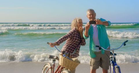 Senior Couple Taking Selfie on Beach with Bicycles - Download Free Stock Images Pikwizard.com