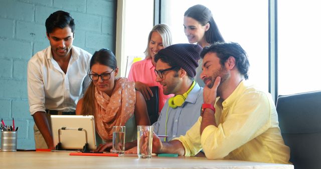 Young professionals collaborating around tablet in modern office - Download Free Stock Images Pikwizard.com