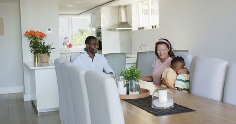 Happy Family Gathering Around Dining Table in Bright Modern Kitchen