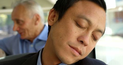 Businessman Sleeping on a City Bus during Commute